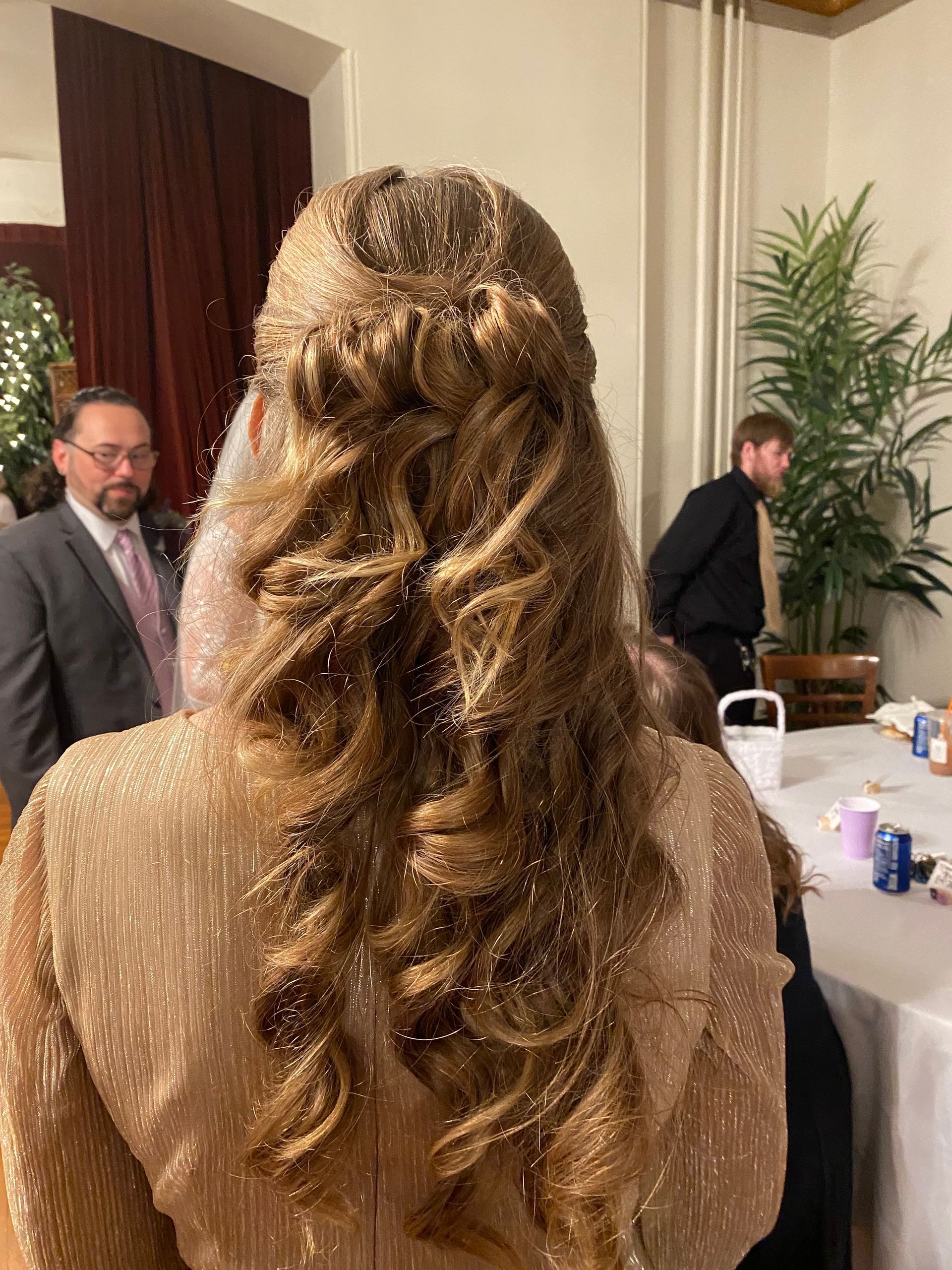 The back of a woman 's head with her hair in a half up half down hairstyle.