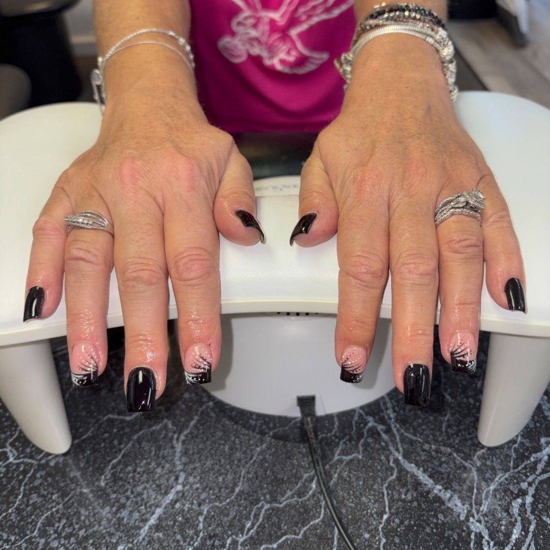A woman's hands with a black and white glitter design.