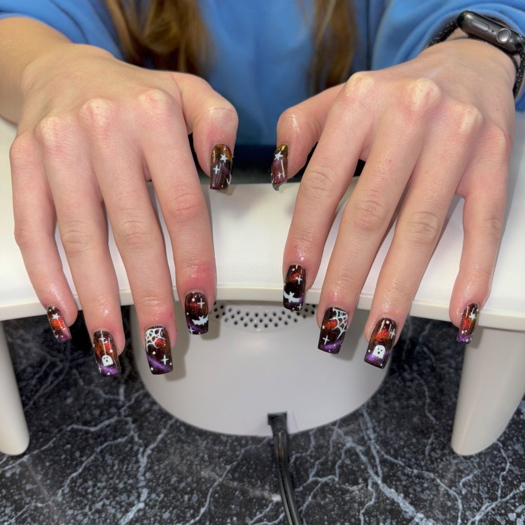 A woman's hands with a spooky manicure design.