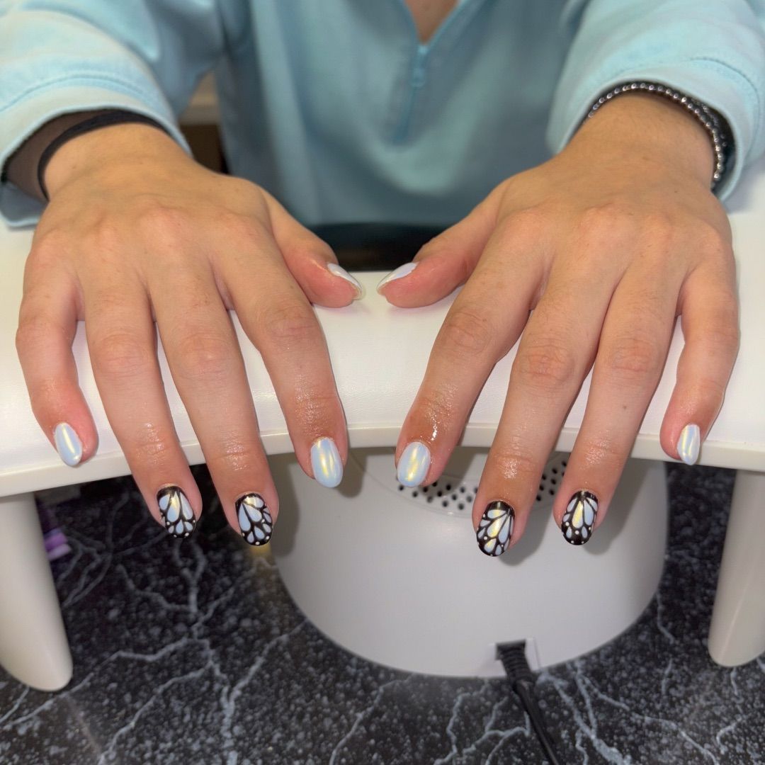 A woman's hands with butterfly wings manicure design.