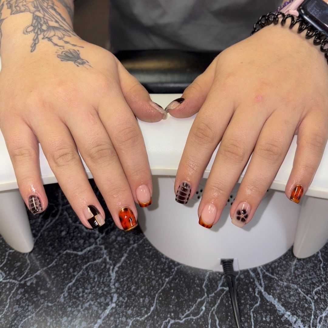 A woman's hands with tortoise shells manicure design.