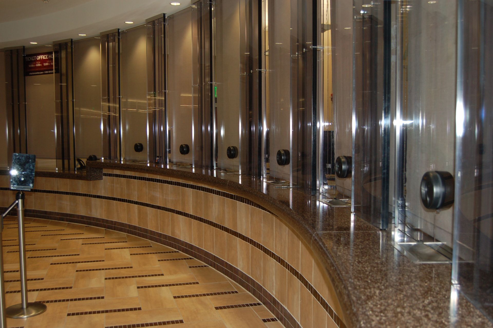 Curved row of mirrored elevator doors in a glossy hotel or office lobby corridor