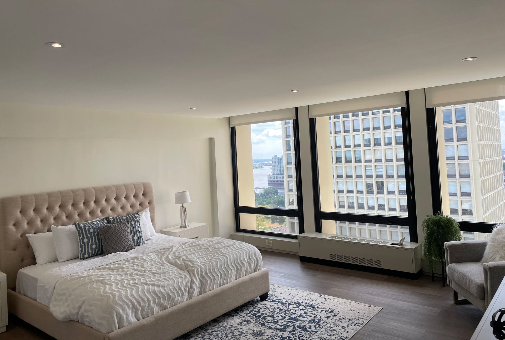 A bedroom with a large bed and lots of windows