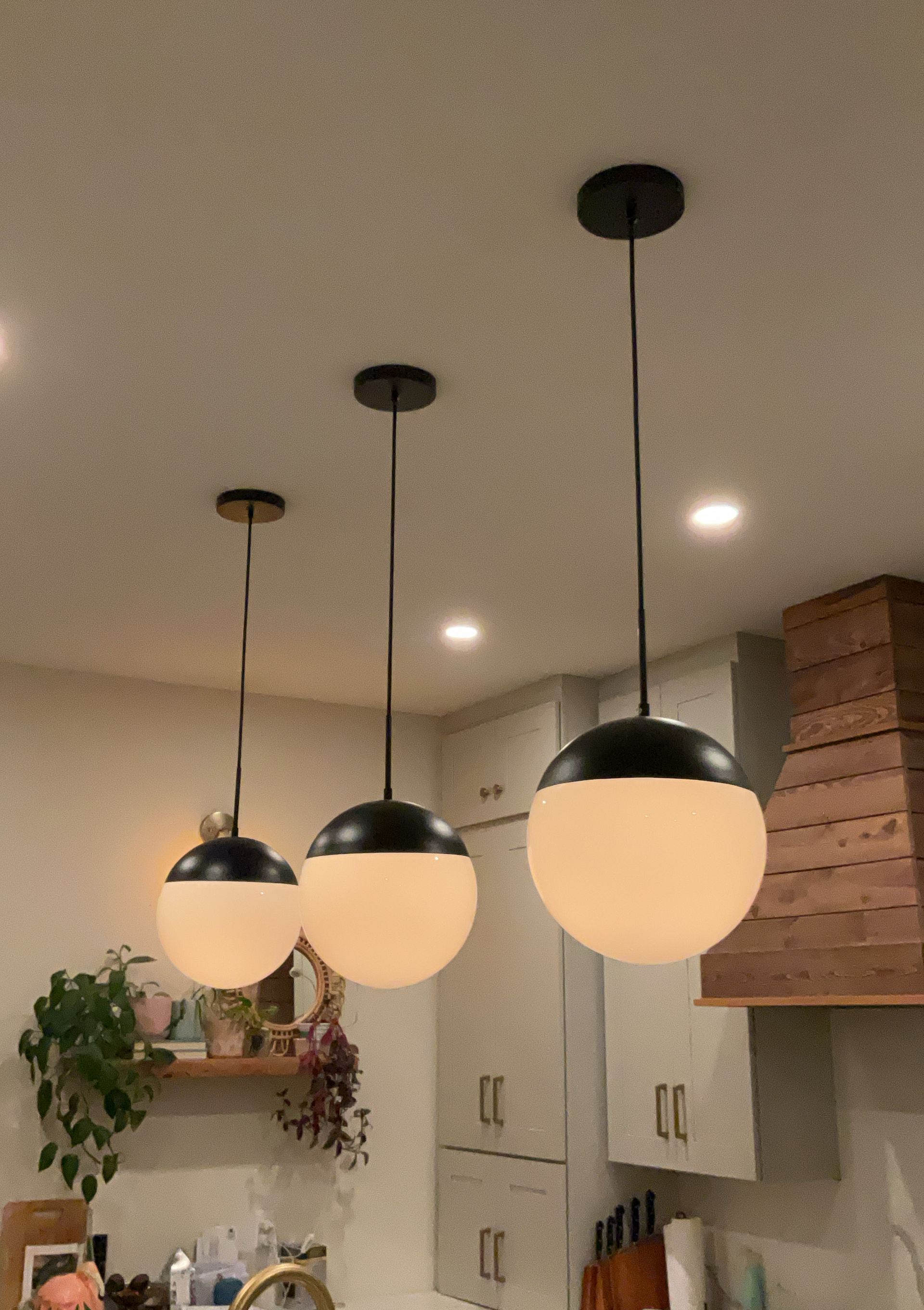 Three pendant lights are hanging from the ceiling in a kitchen
