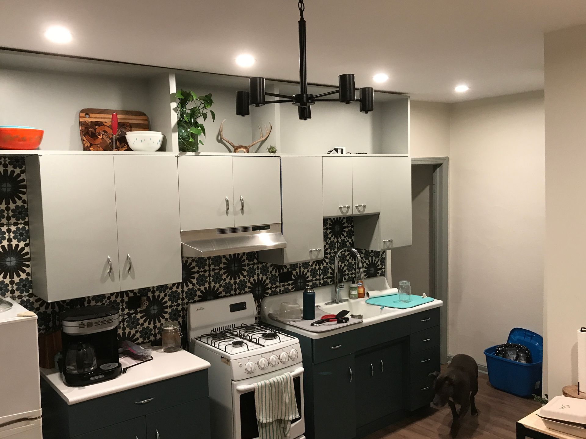 A kitchen with a stove , sink , and cabinets