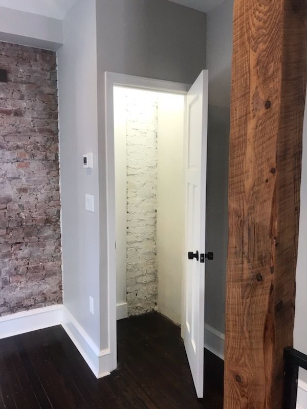 A room with a brick wall and a wooden beam.