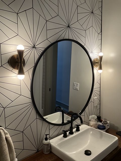 A bathroom with a sink and a round mirror