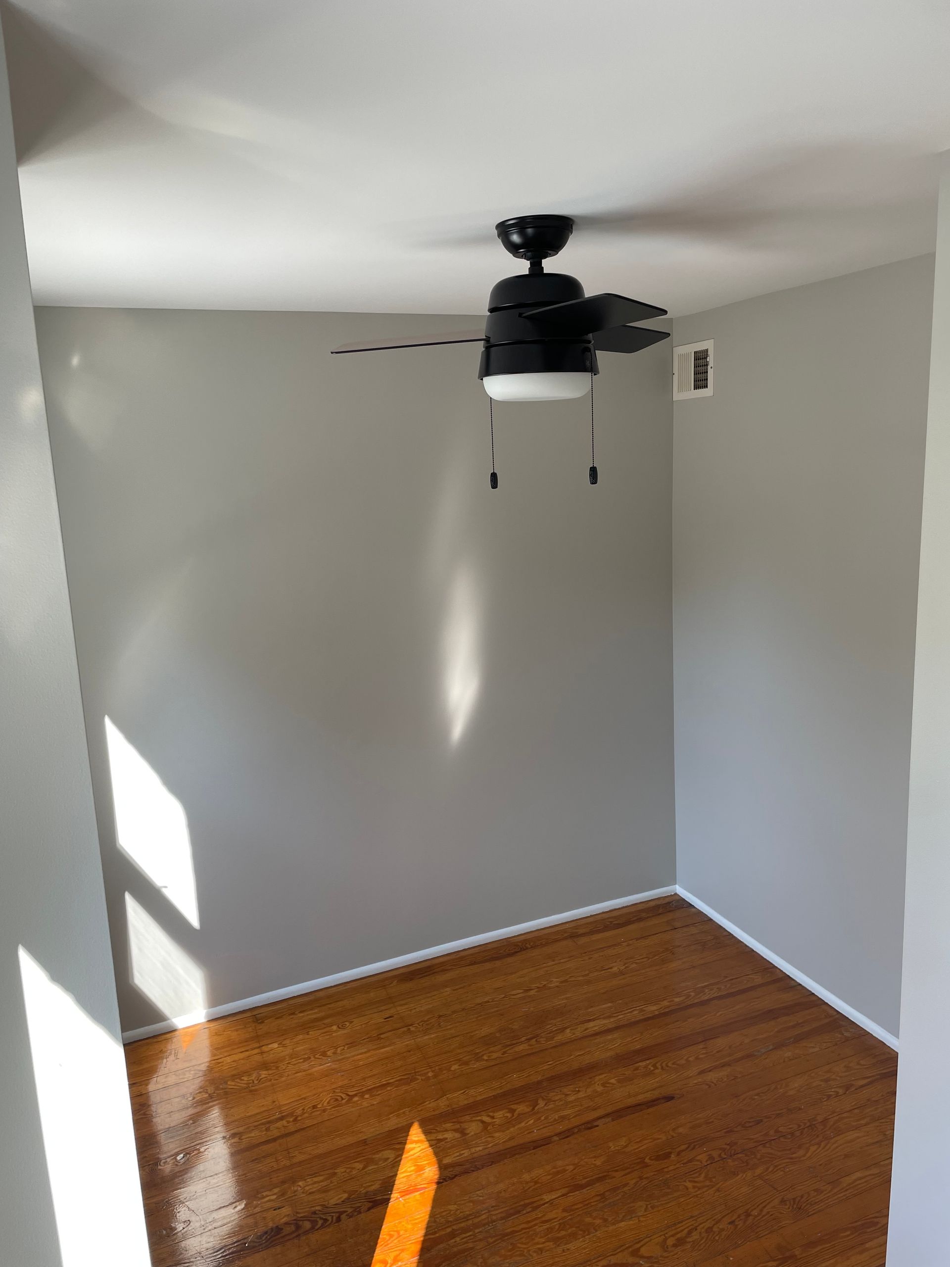 There is a ceiling fan in the corner of the room.