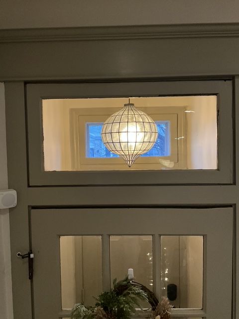 A door with a window and a light hanging from it