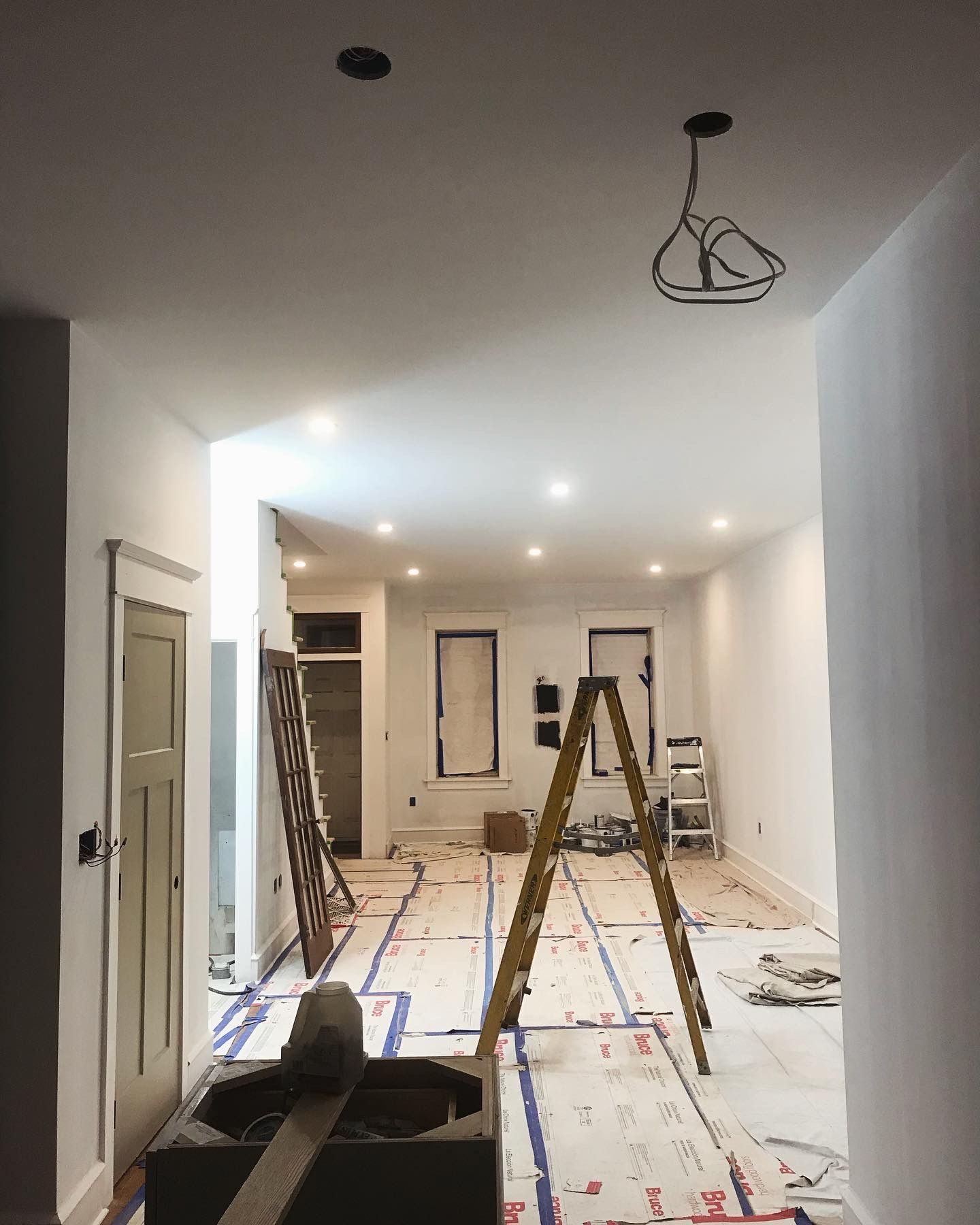 A ladder is sitting on the floor of a room under construction.