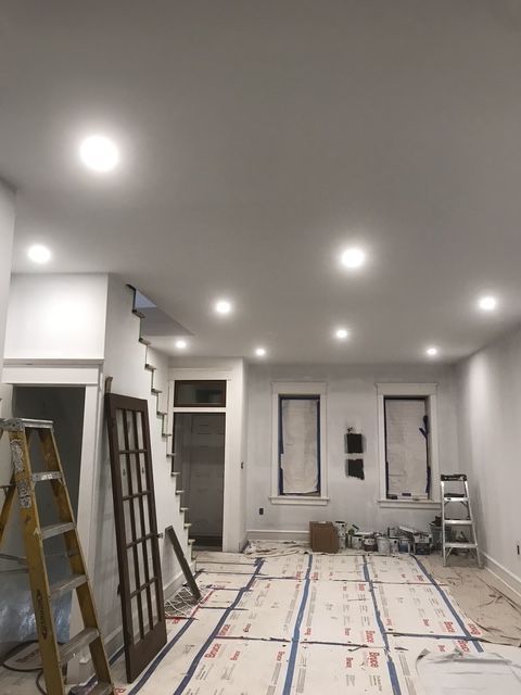 A room that is being painted with a ladder on the floor.