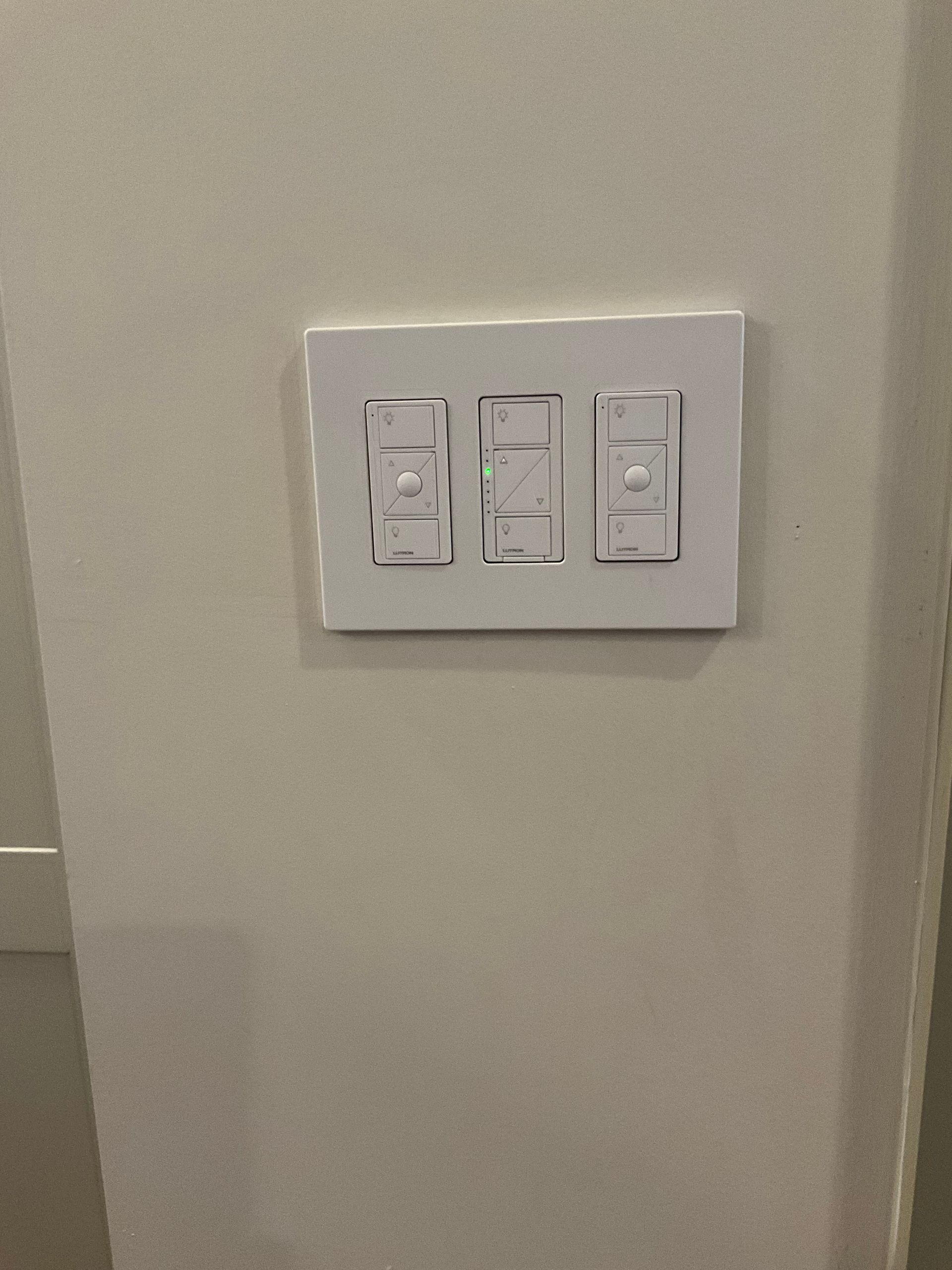 A white light switch is hanging on a white wall.