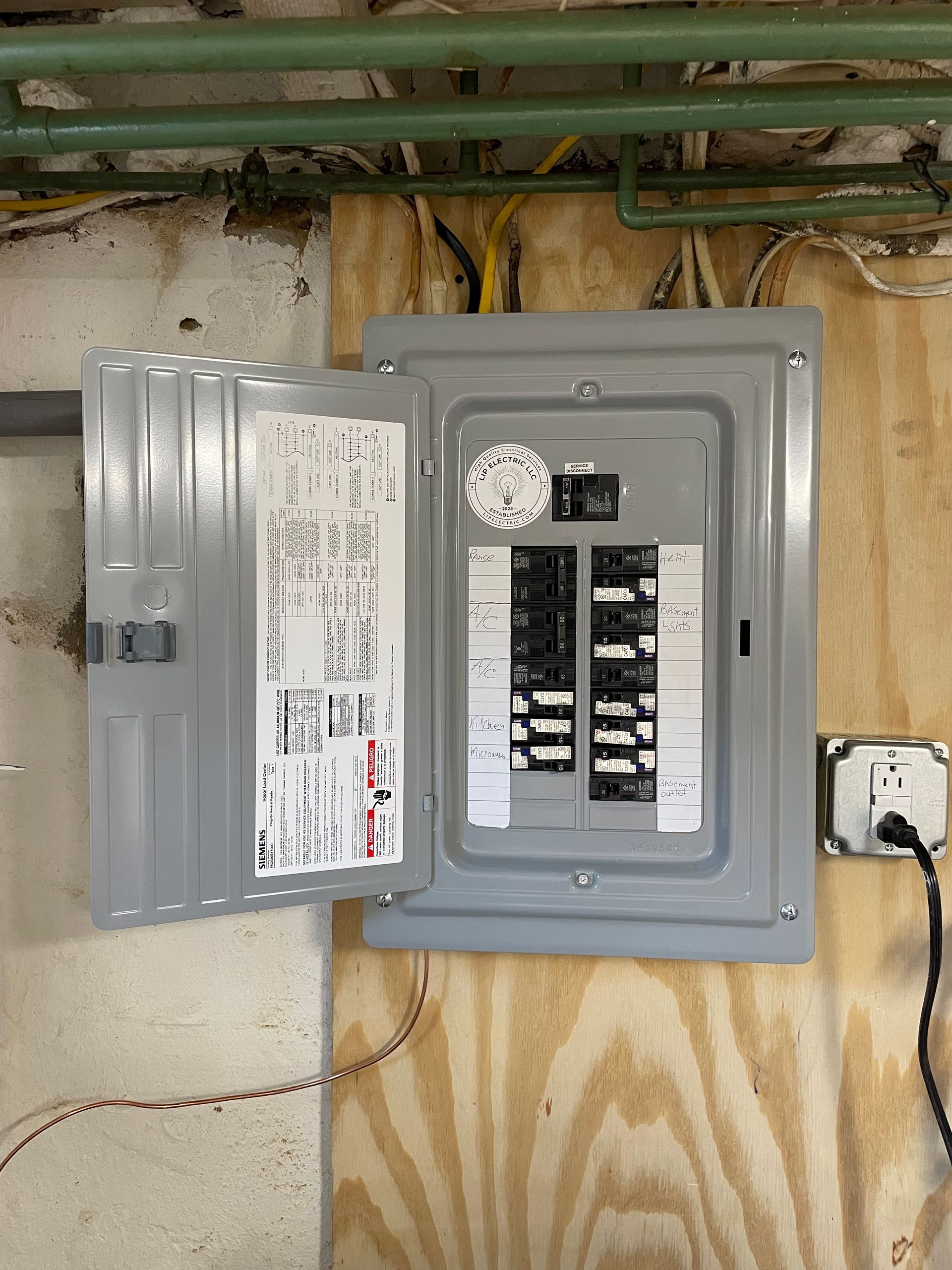 A electrical box is hanging on a wooden wall.