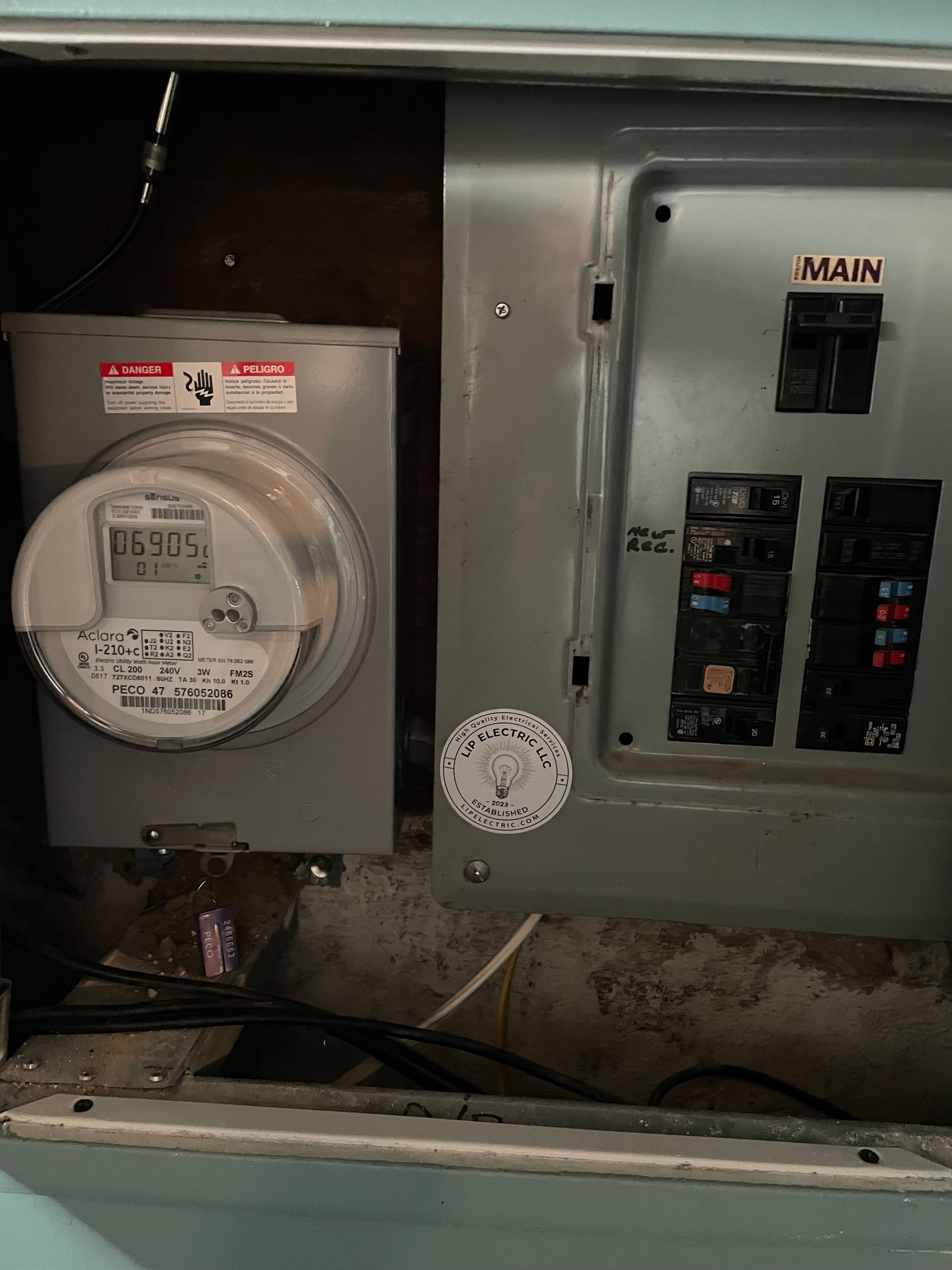 A meter is sitting next to a electrical box.