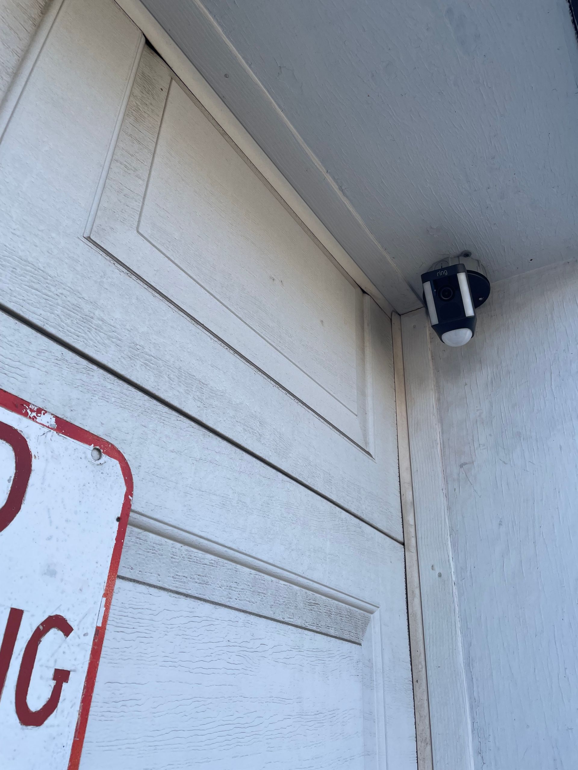 A no parking sign is on the side of a garage door