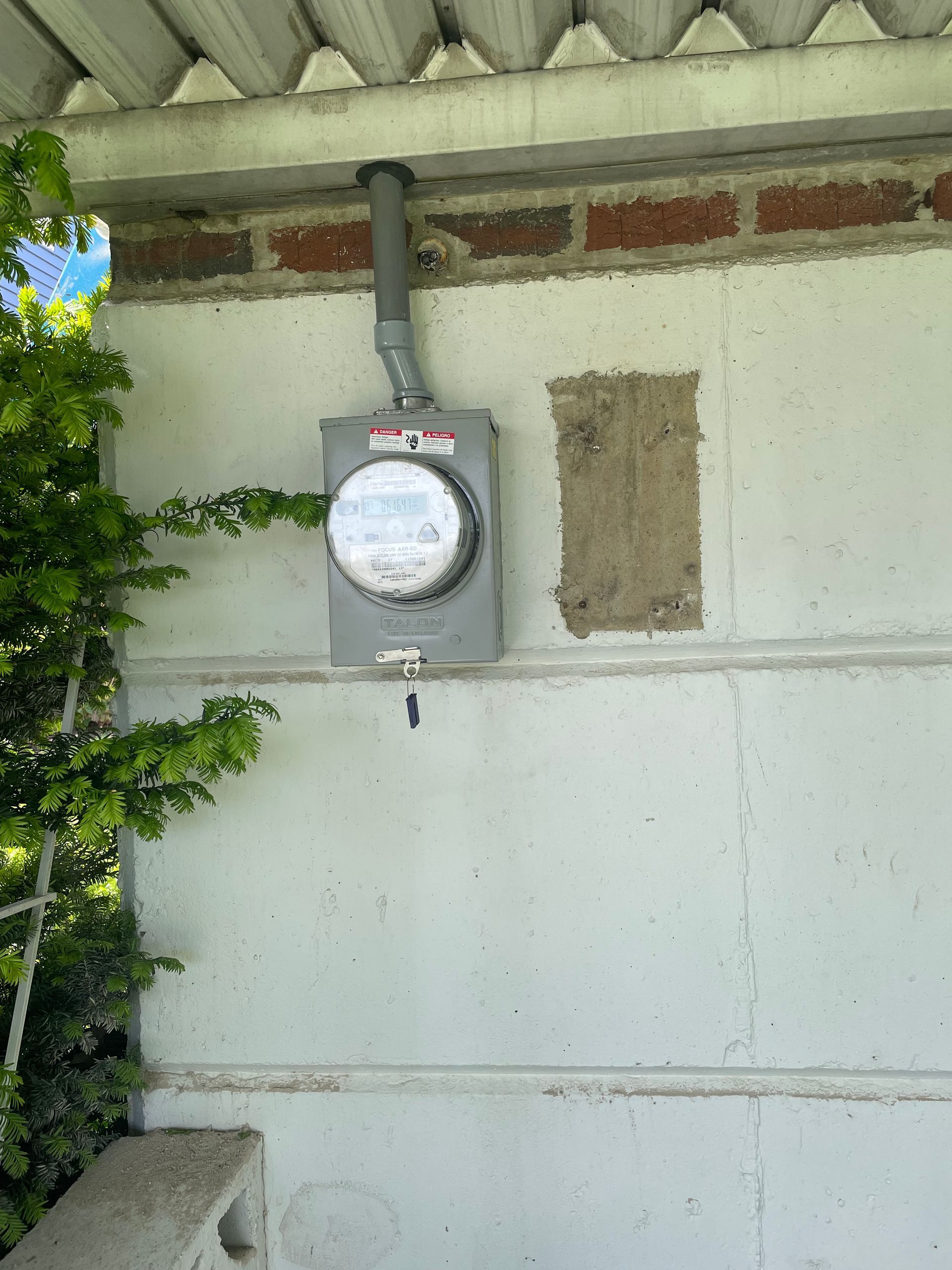 A meter is hanging on the side of a building.