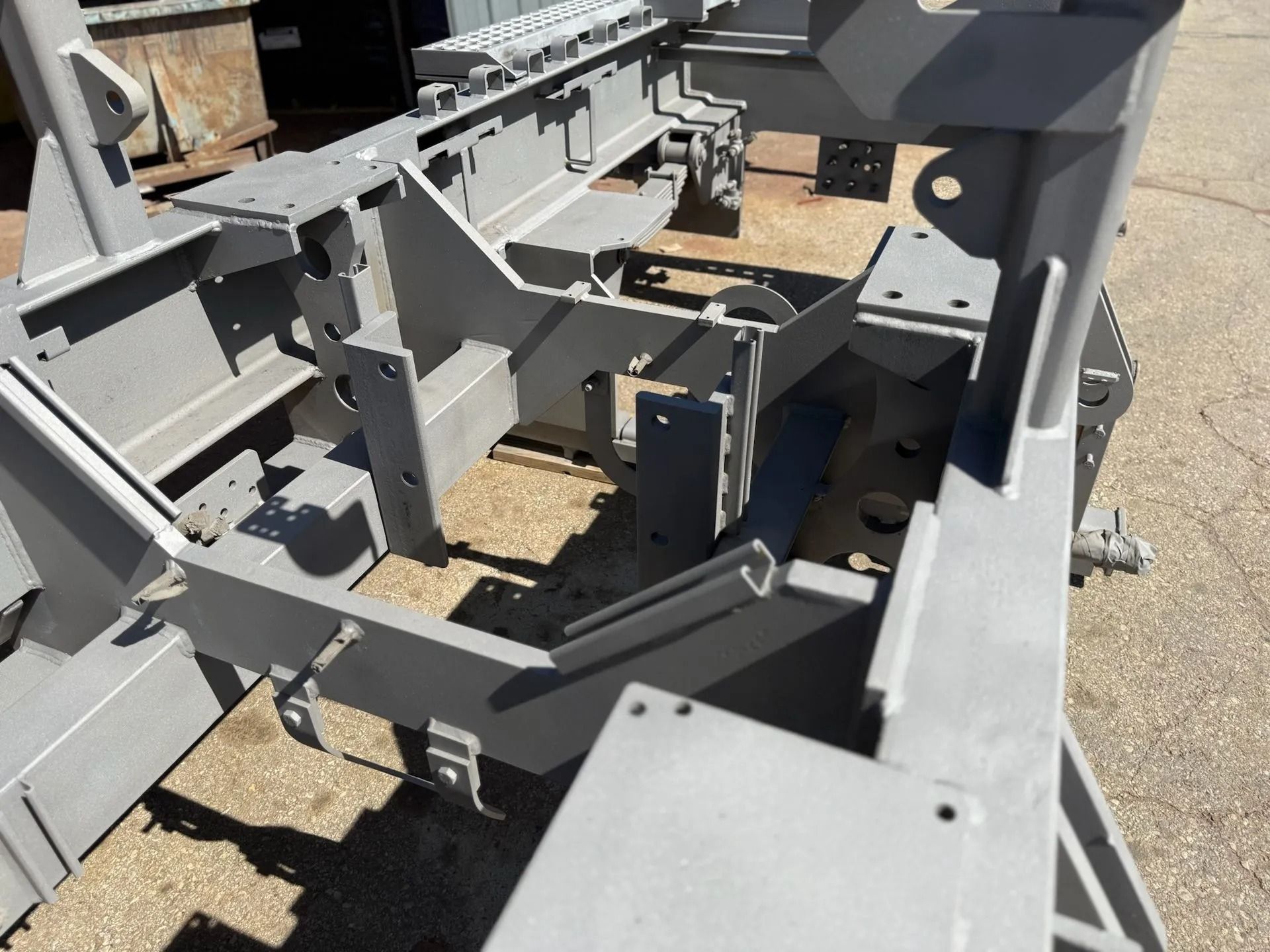 Gray metal industrial frame with open center section and structural supports.