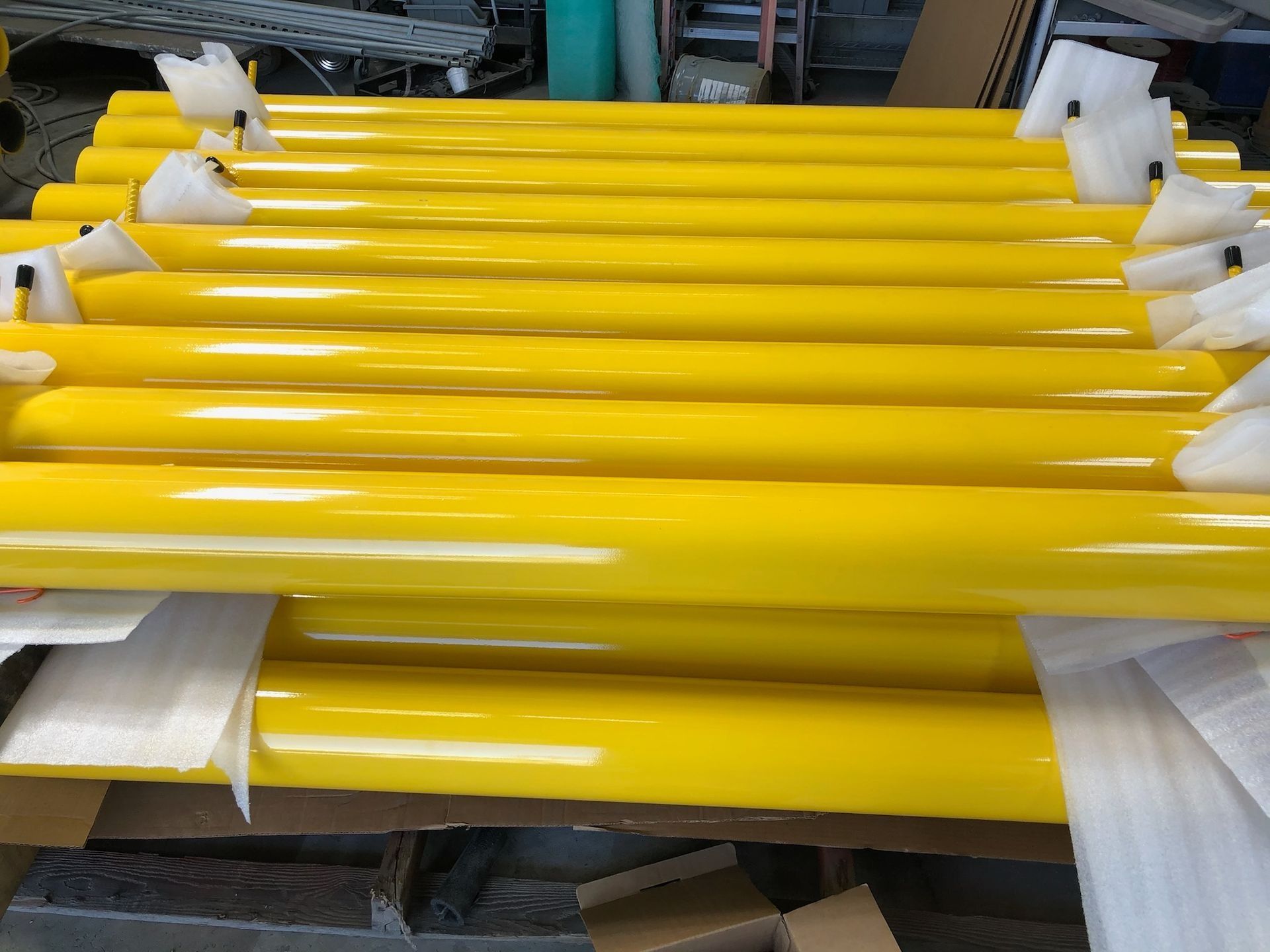 Yellow cylindrical objects bundled together, possibly tubes or rods.