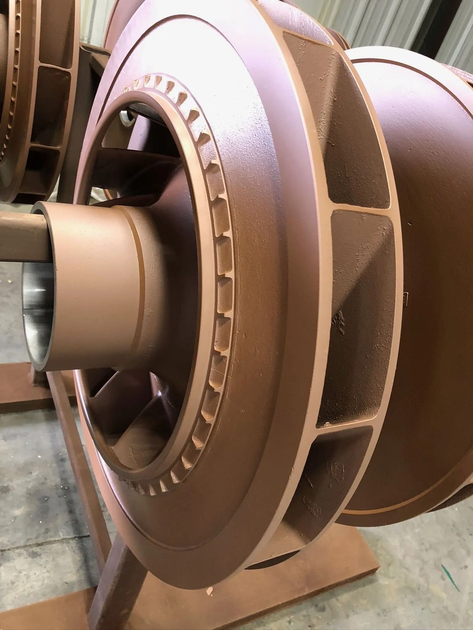 Brown impeller assembly, possibly for a pump, on a stand.