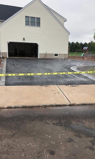 House exterior with fresh blacktop driveway and yellow caution tape across the front entrance