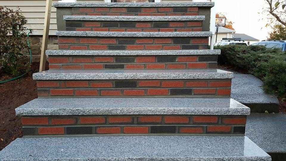 Brick-and-concrete outdoor stairs with gray side steps and small garden borders