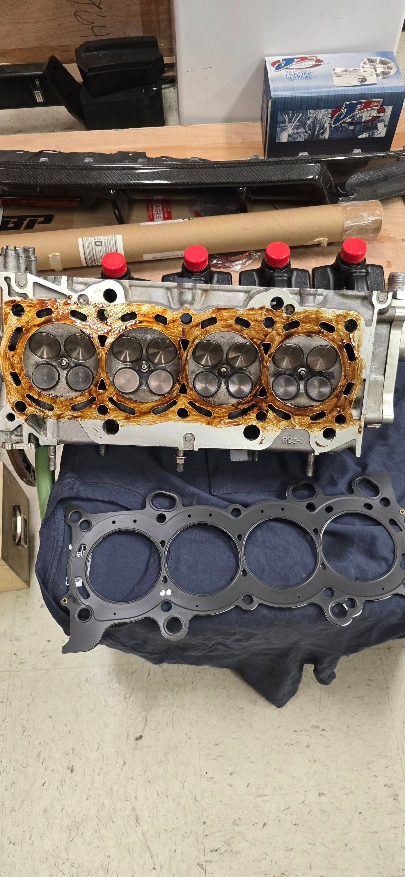 Engine cylinder head with gasket, showing valves and combustion chambers.