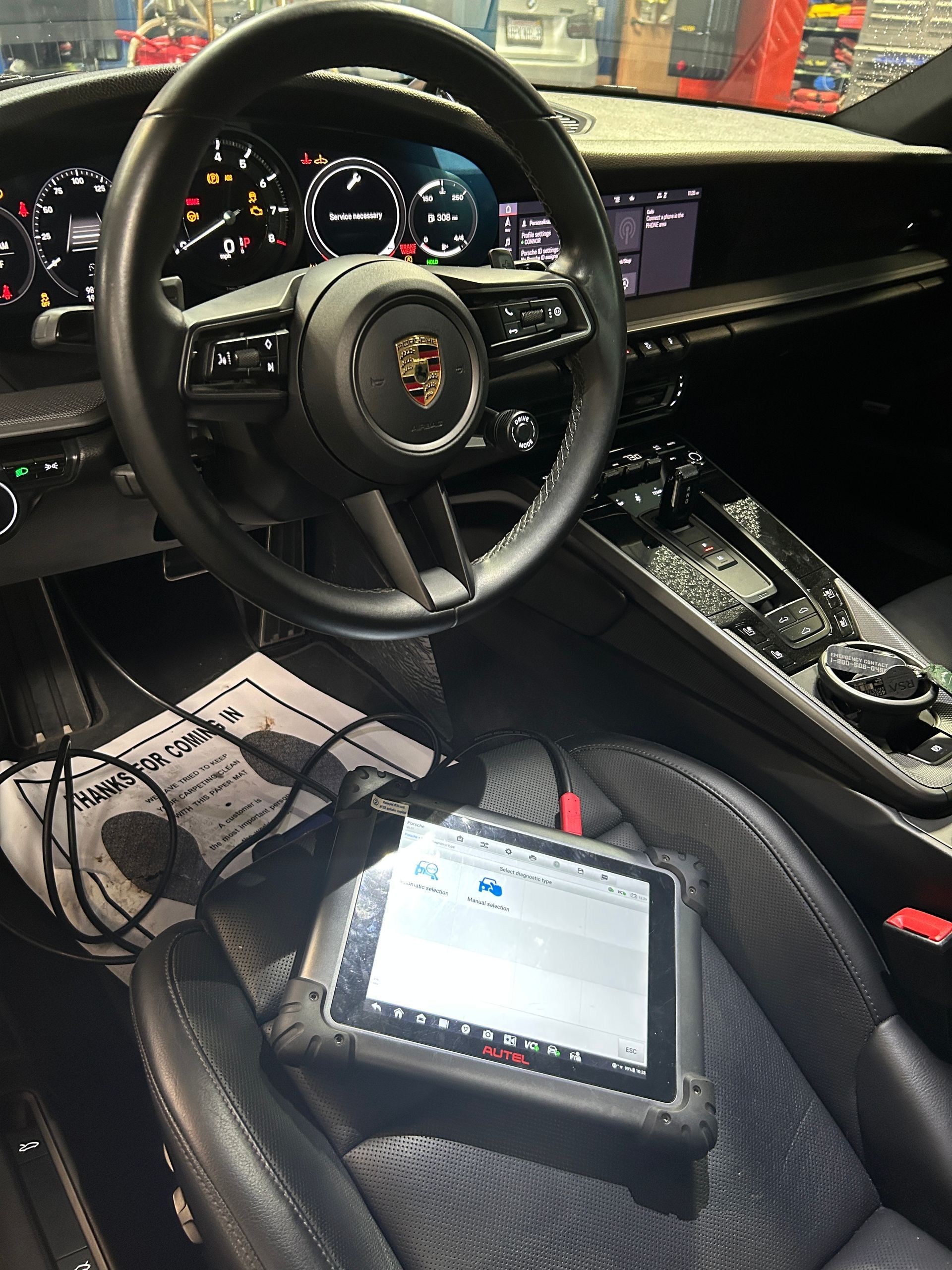 Porsche steering wheel and dashboard with two diagnostic tablets inside the car interior