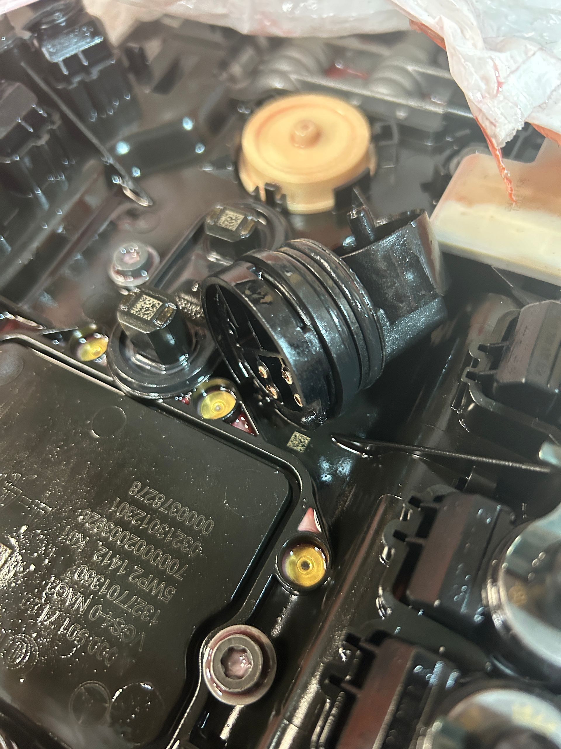 Close-up of a camera’s internal mechanism with black plastic parts and a yellow gear.