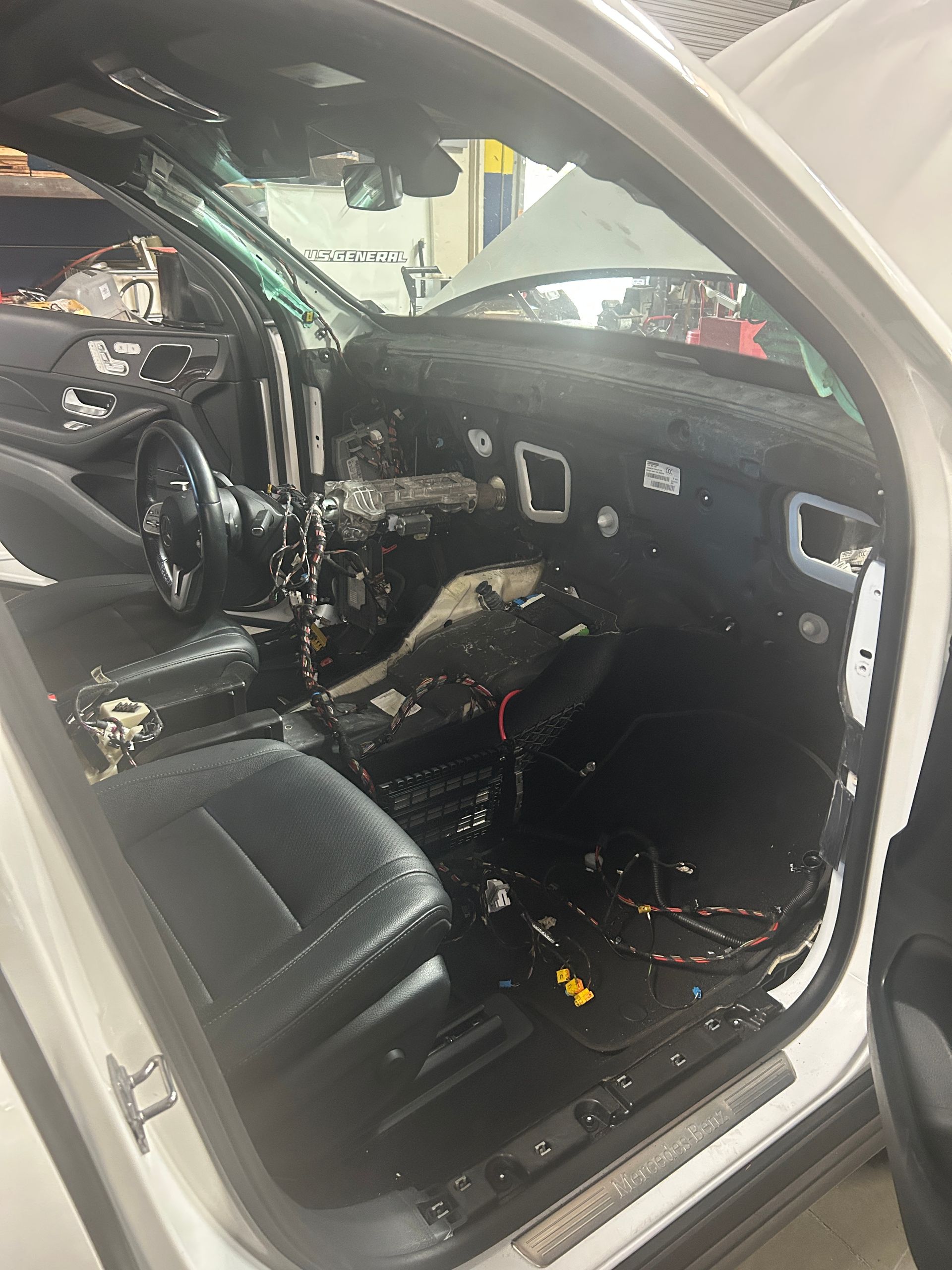 Damaged car interior with deployed airbags, broken glass, and torn upholstery after a crash