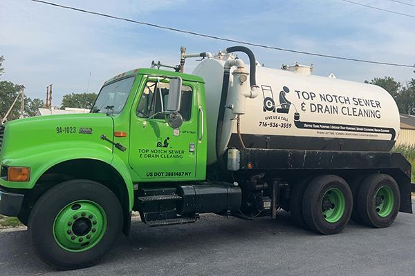 A bright green service truck parked outdoors, featuring a large white cylindrical tank labeled 