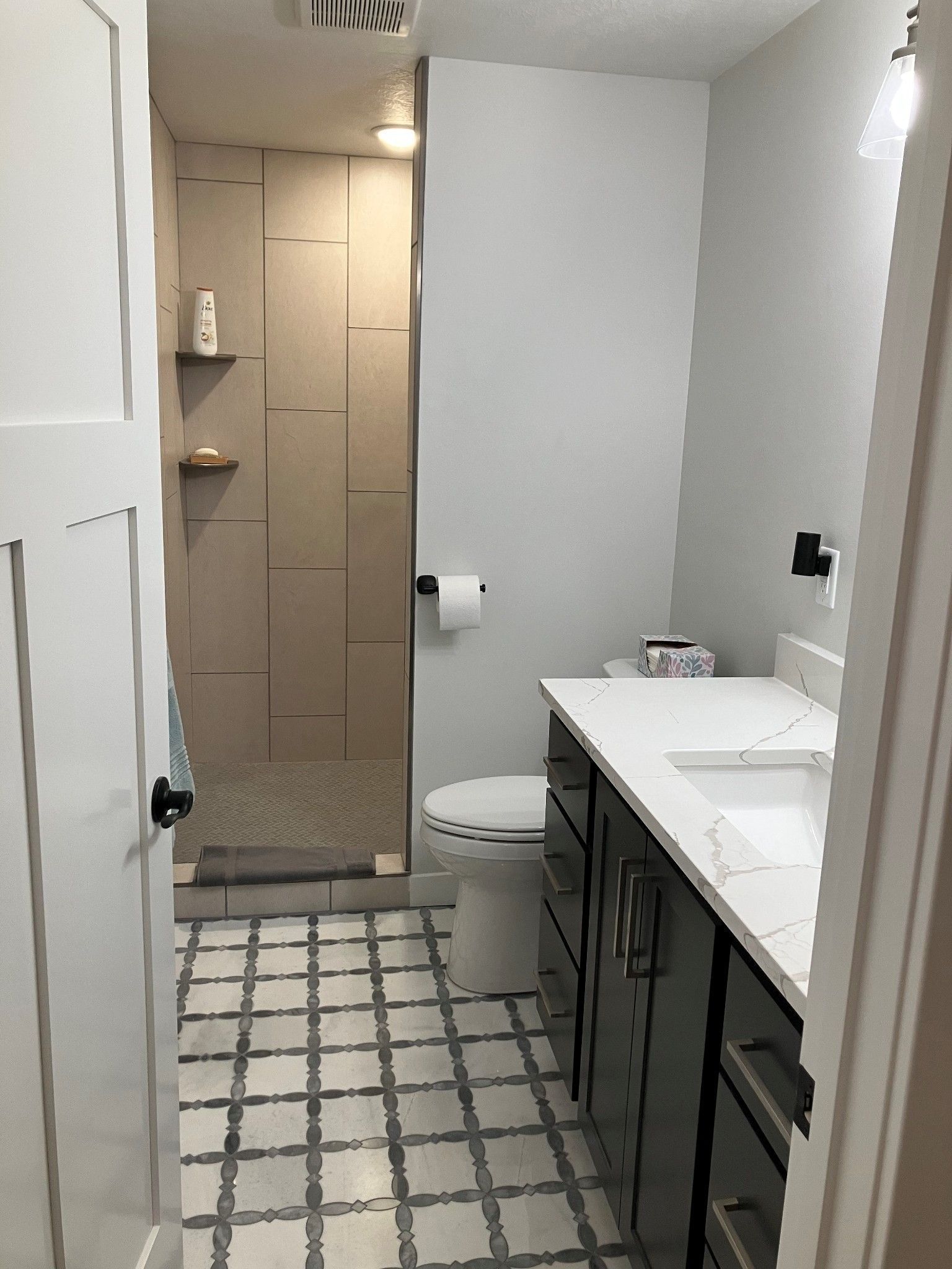 A bathroom with a toilet , sink , and shower.