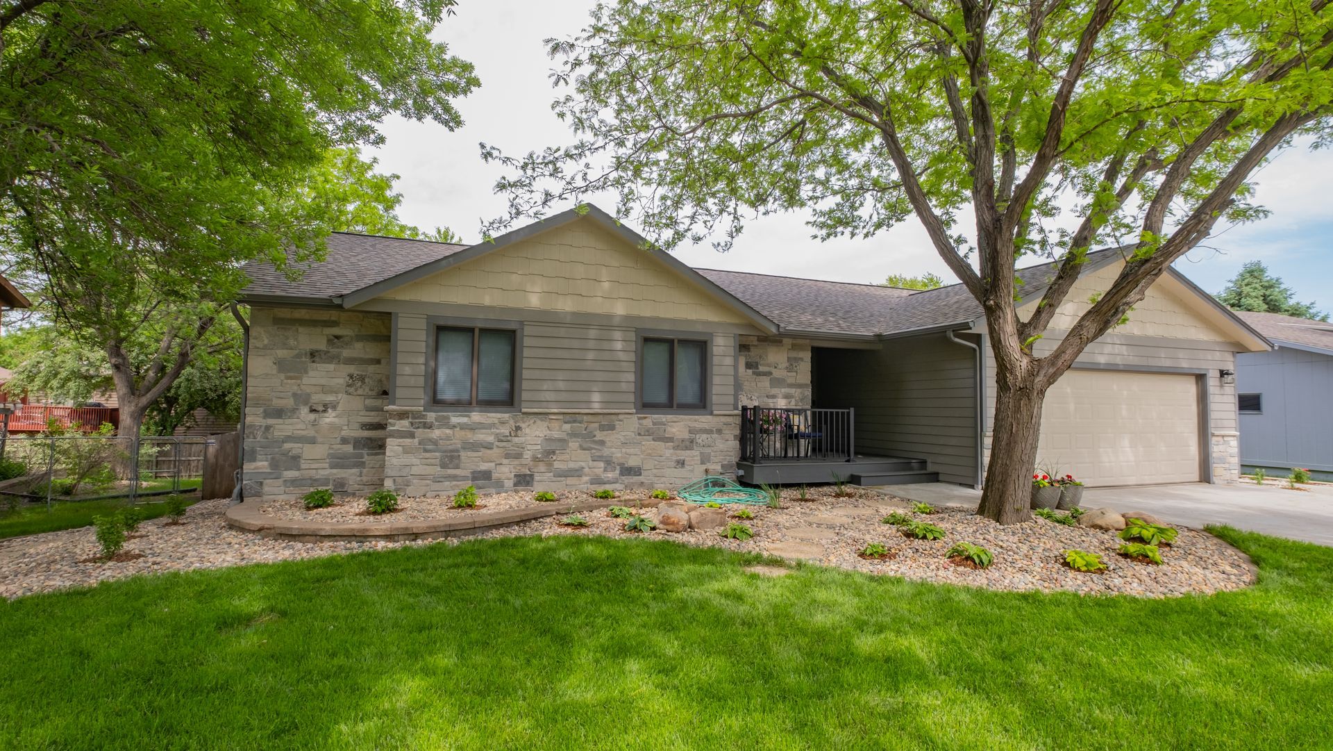 A house with a large lawn and trees in front of it.