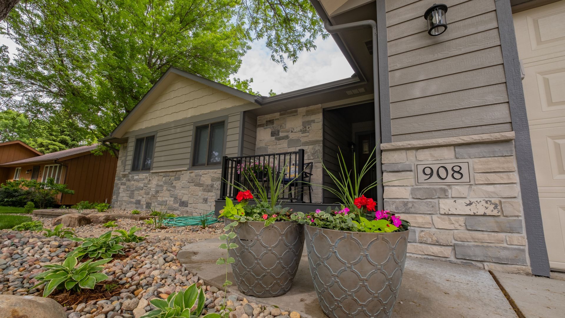 A house with two potted plants in front of it.