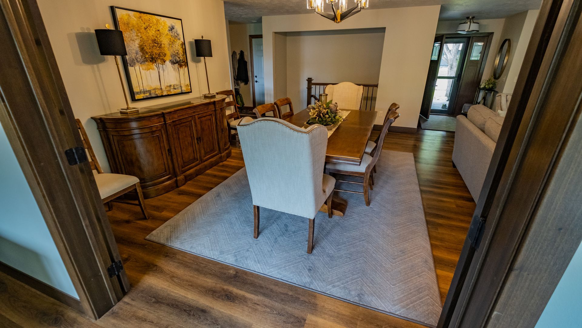 A dining room with a table and chairs and a rug.