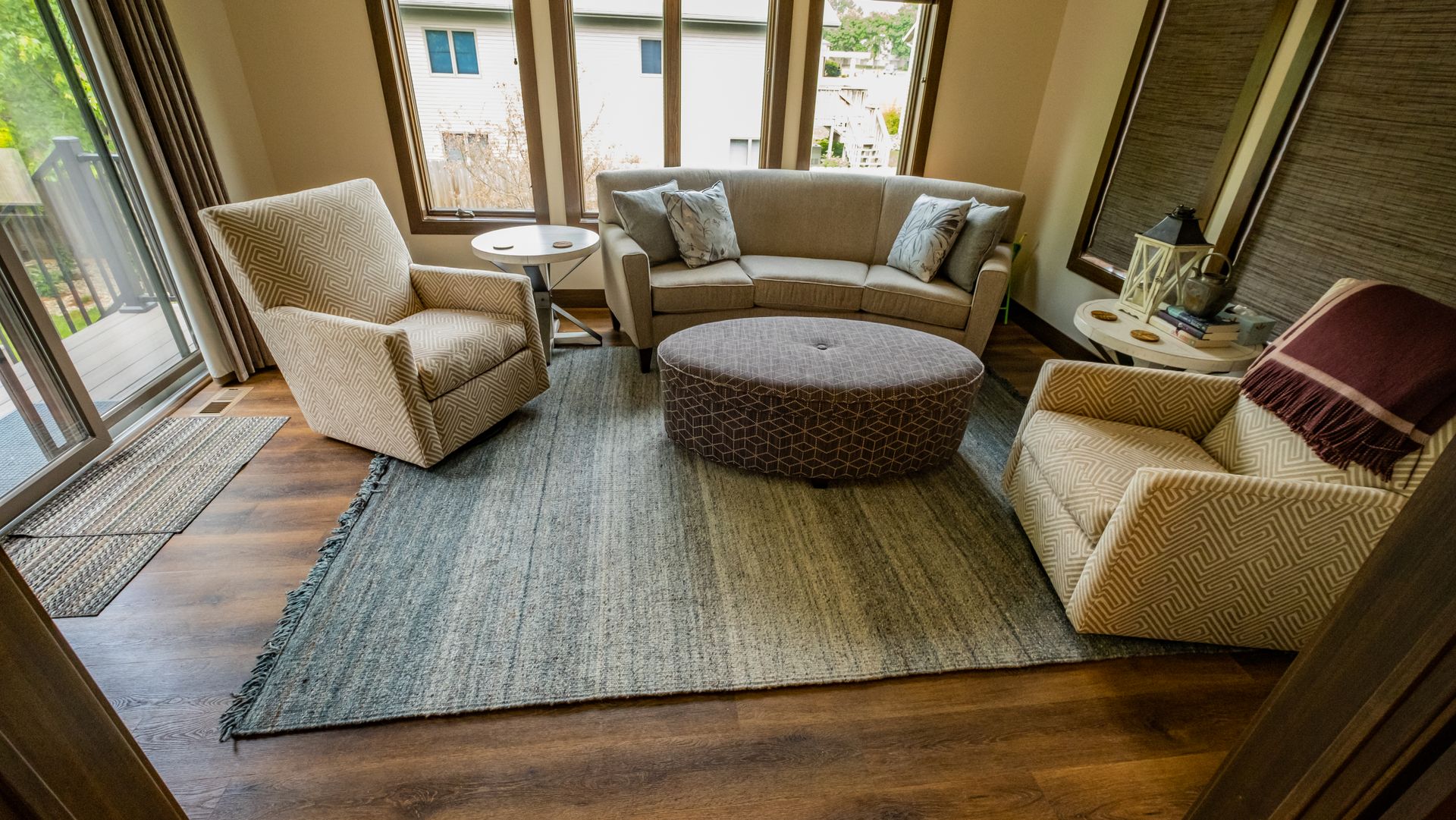 A living room with a couch, chairs, and a rug.