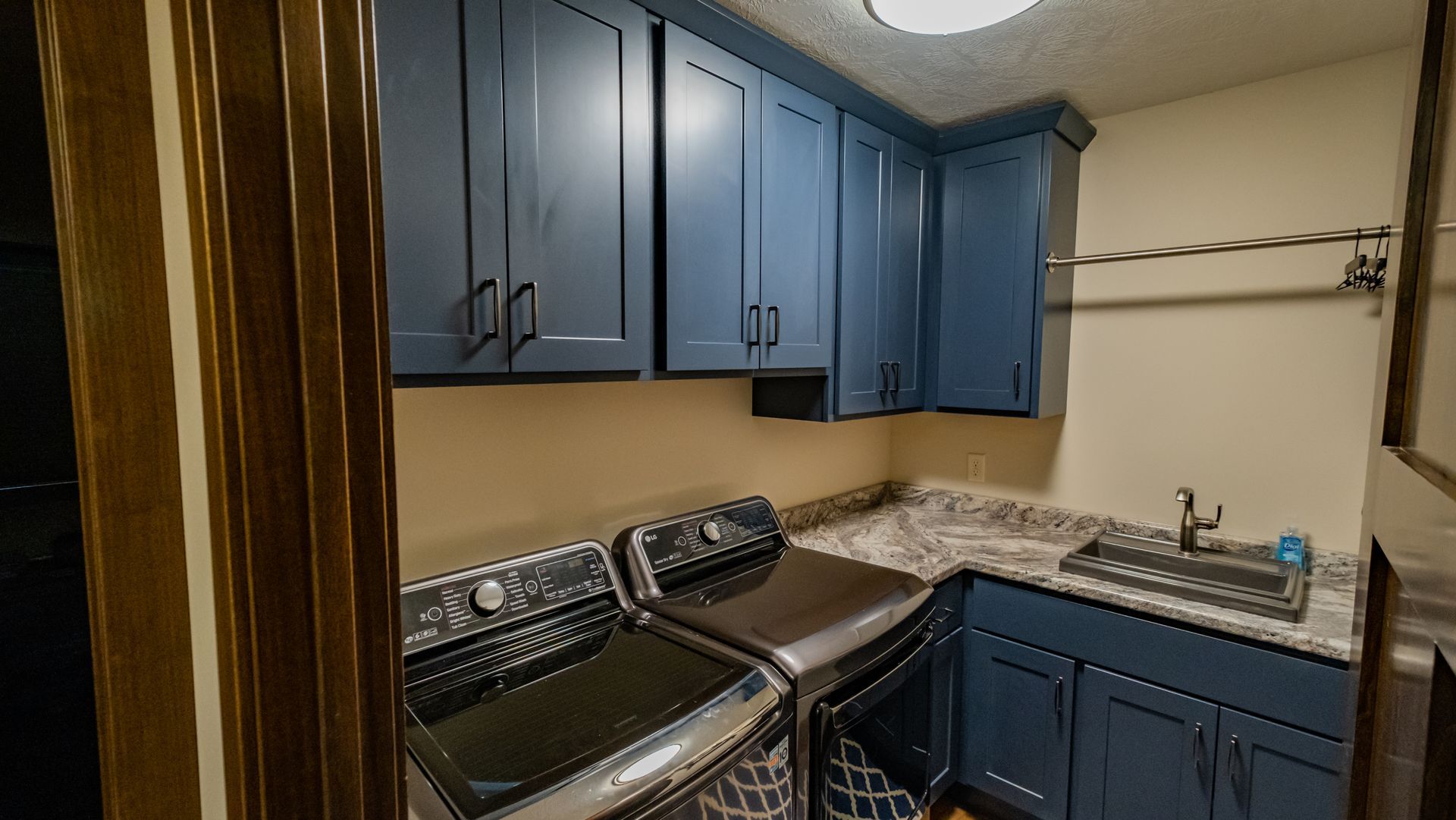 A laundry room with blue cabinets and a washer and dryer