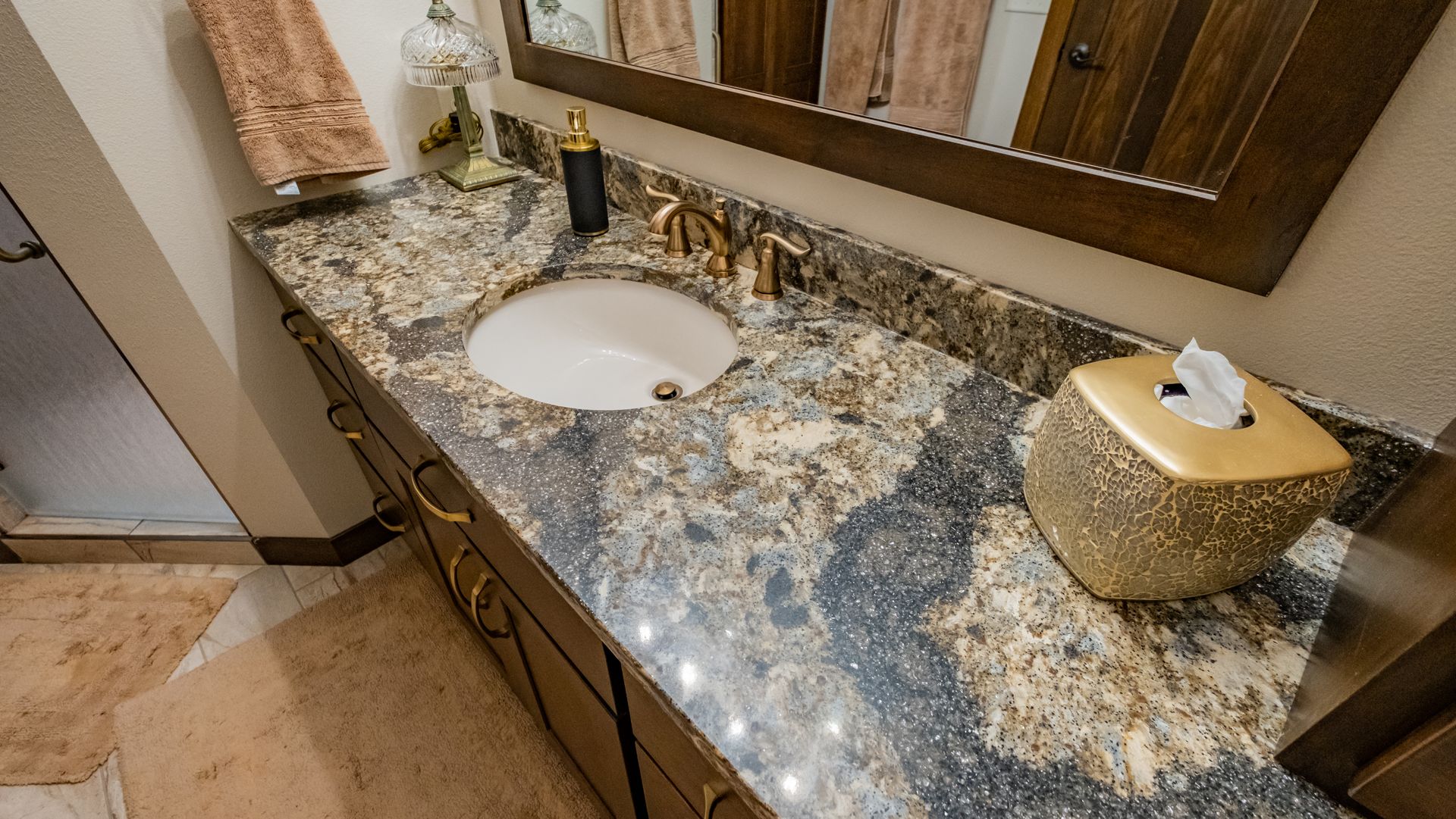 A bathroom with a sink, mirror and tissue box.