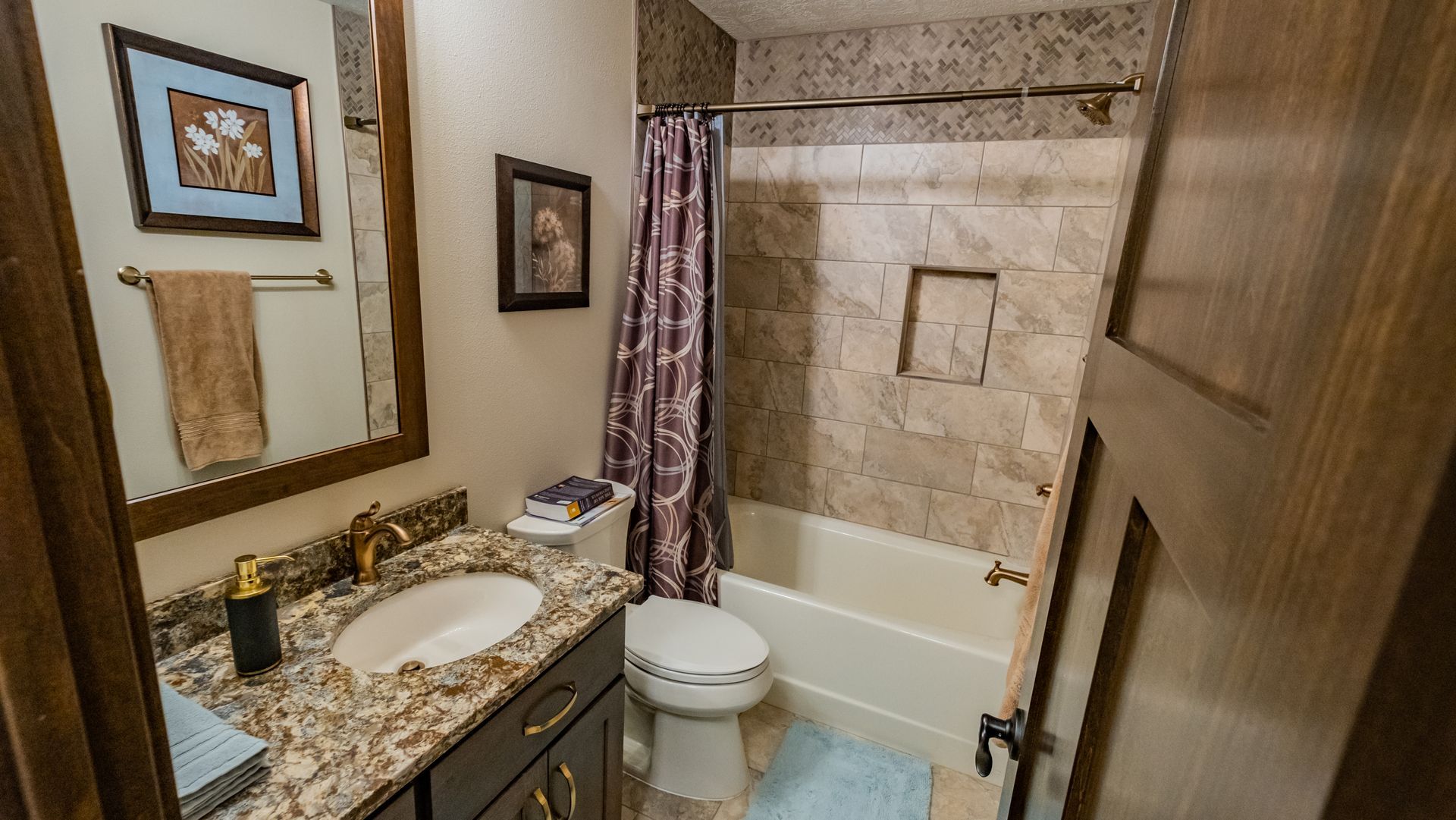 A bathroom with a sink, toilet, tub and mirror.