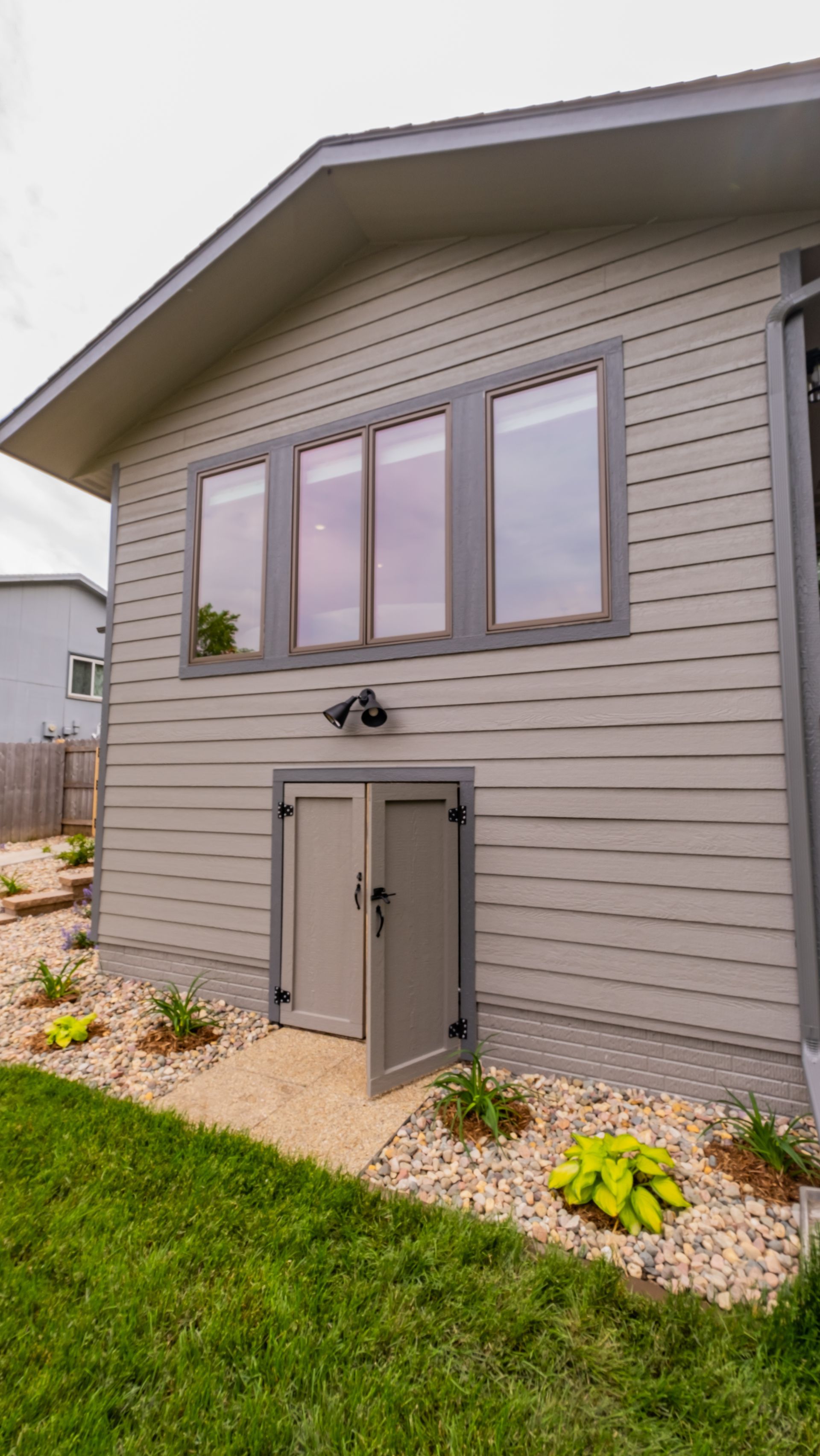 A house with a shed in the basement and a lot of windows.