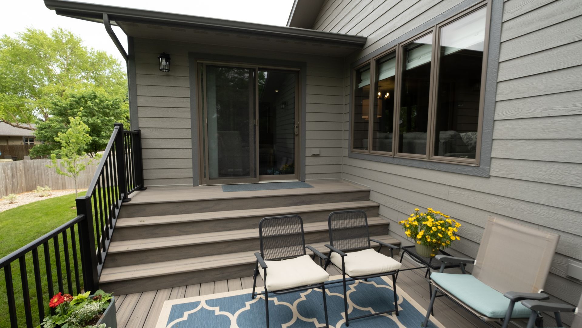 A patio with chairs and a table in front of a house