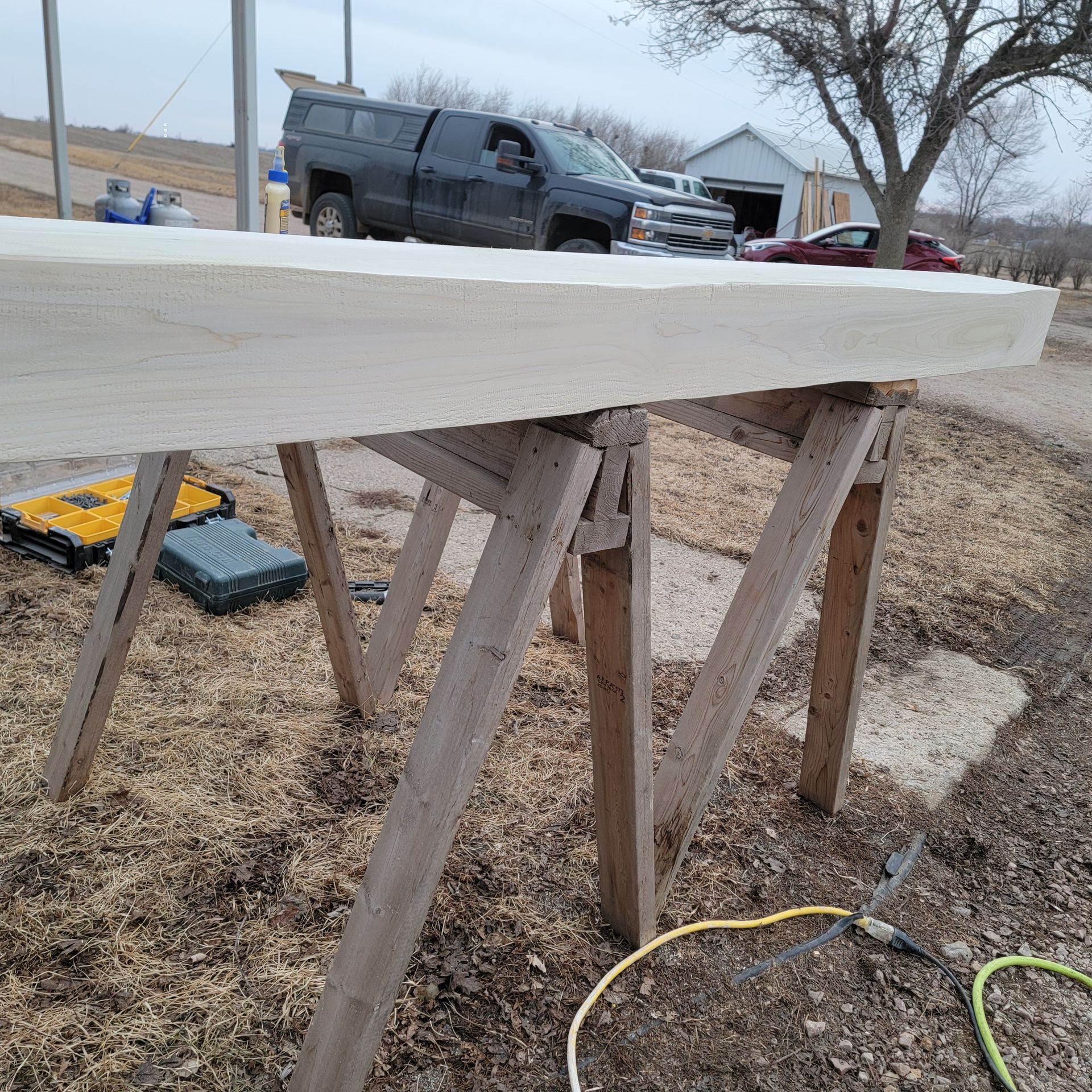 A large piece of wood is sitting on top of a wooden trestle.