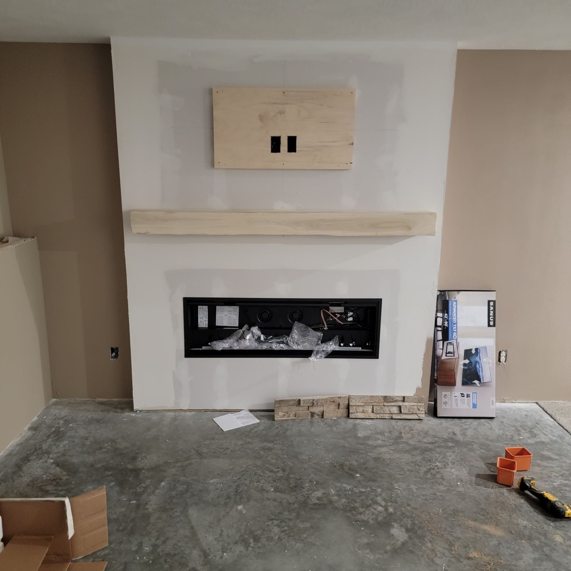 A fireplace is being built in a living room.