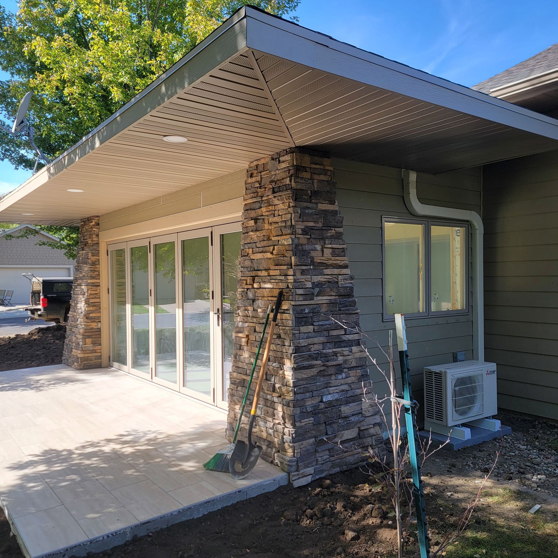 A house with a lot of windows and a stone wall