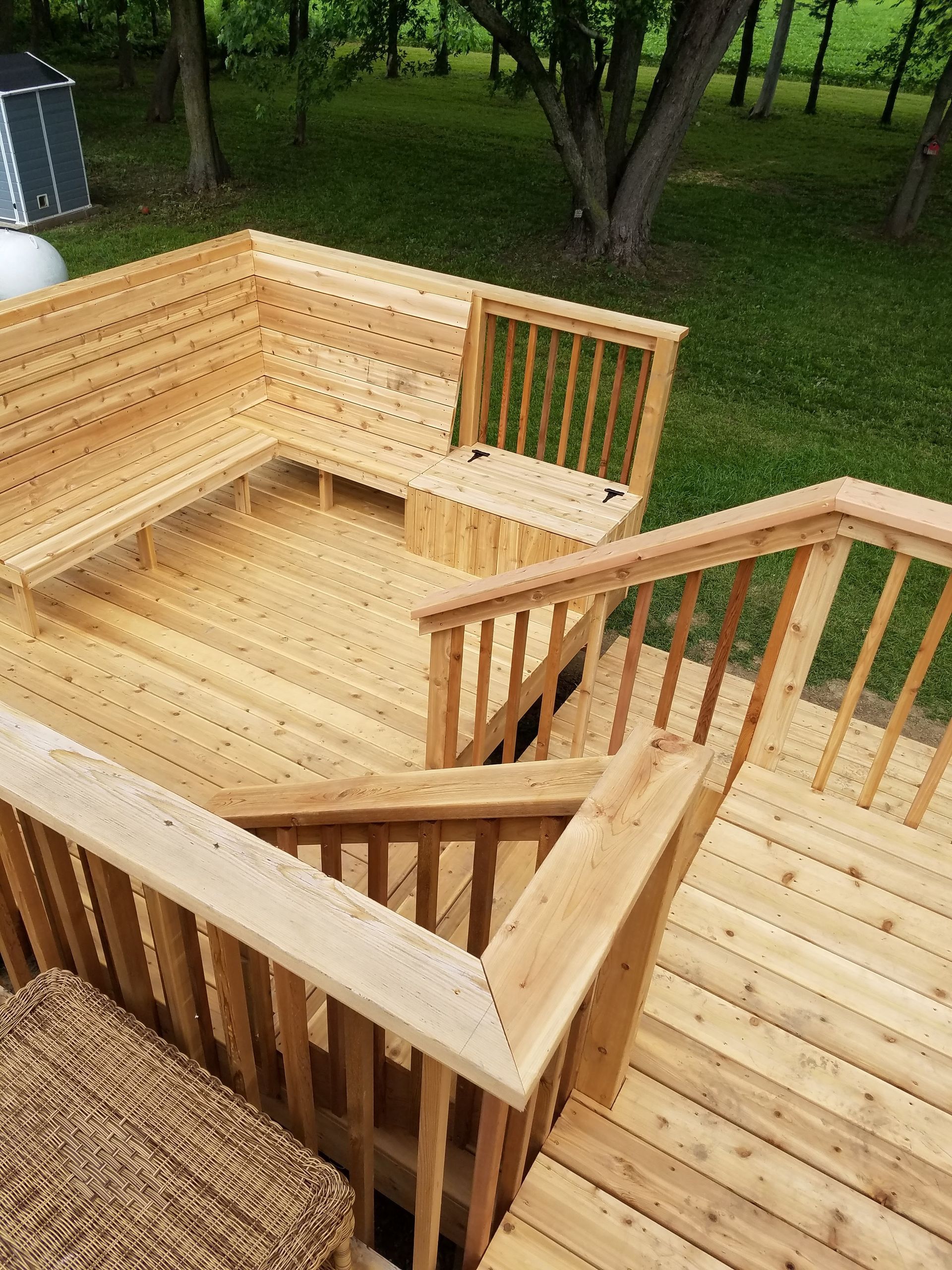 A wooden deck with stairs leading up to it and a bench.