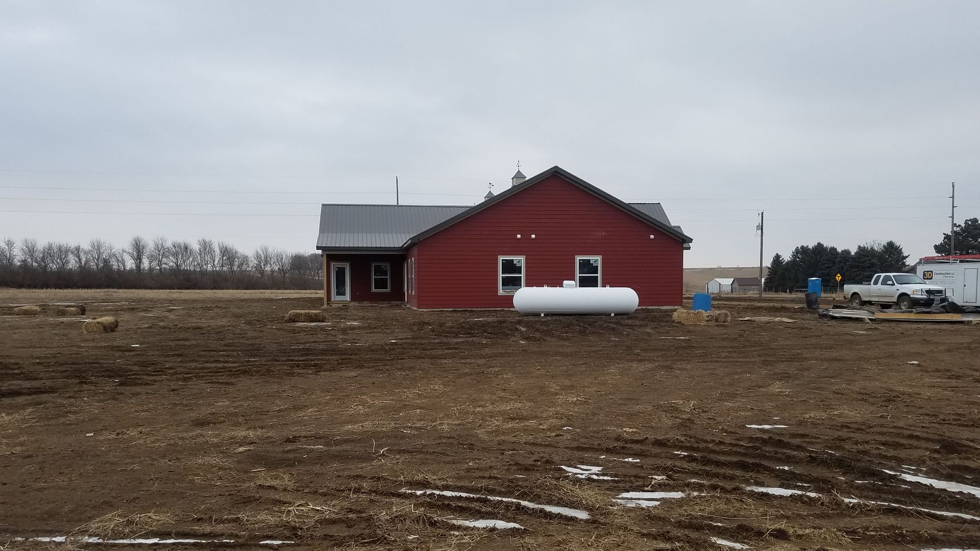 A red house with a white tank in front of it