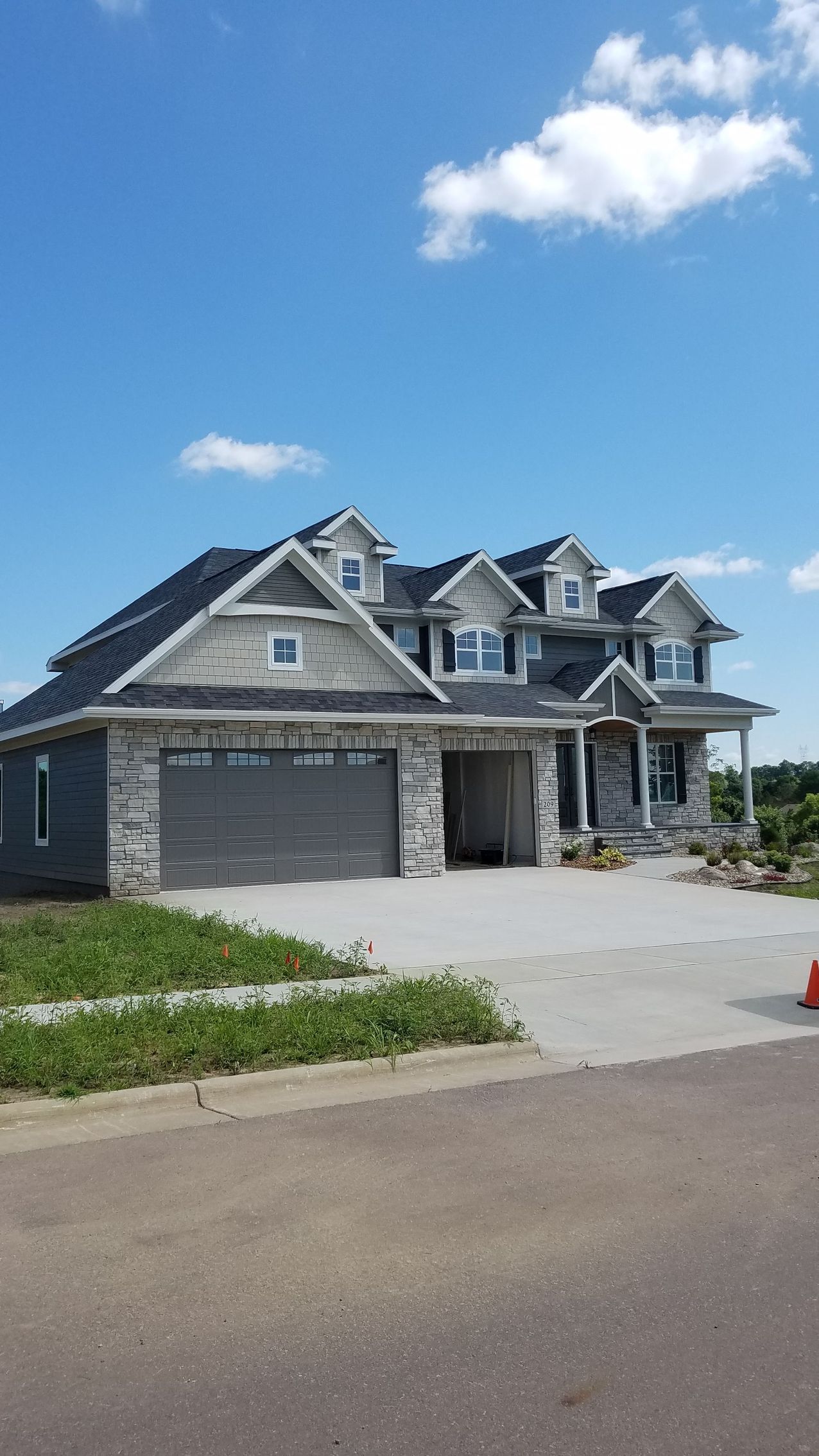 A large house is being built in a residential area on a sunny day.