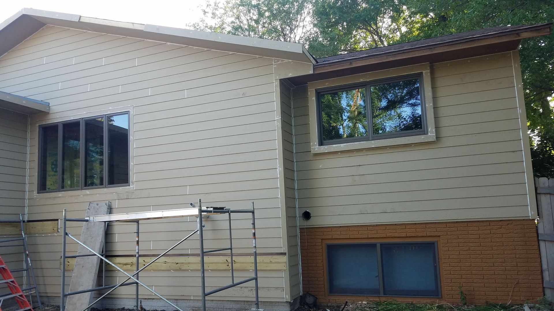 A house with a scaffolding in front of it is being remodeled.