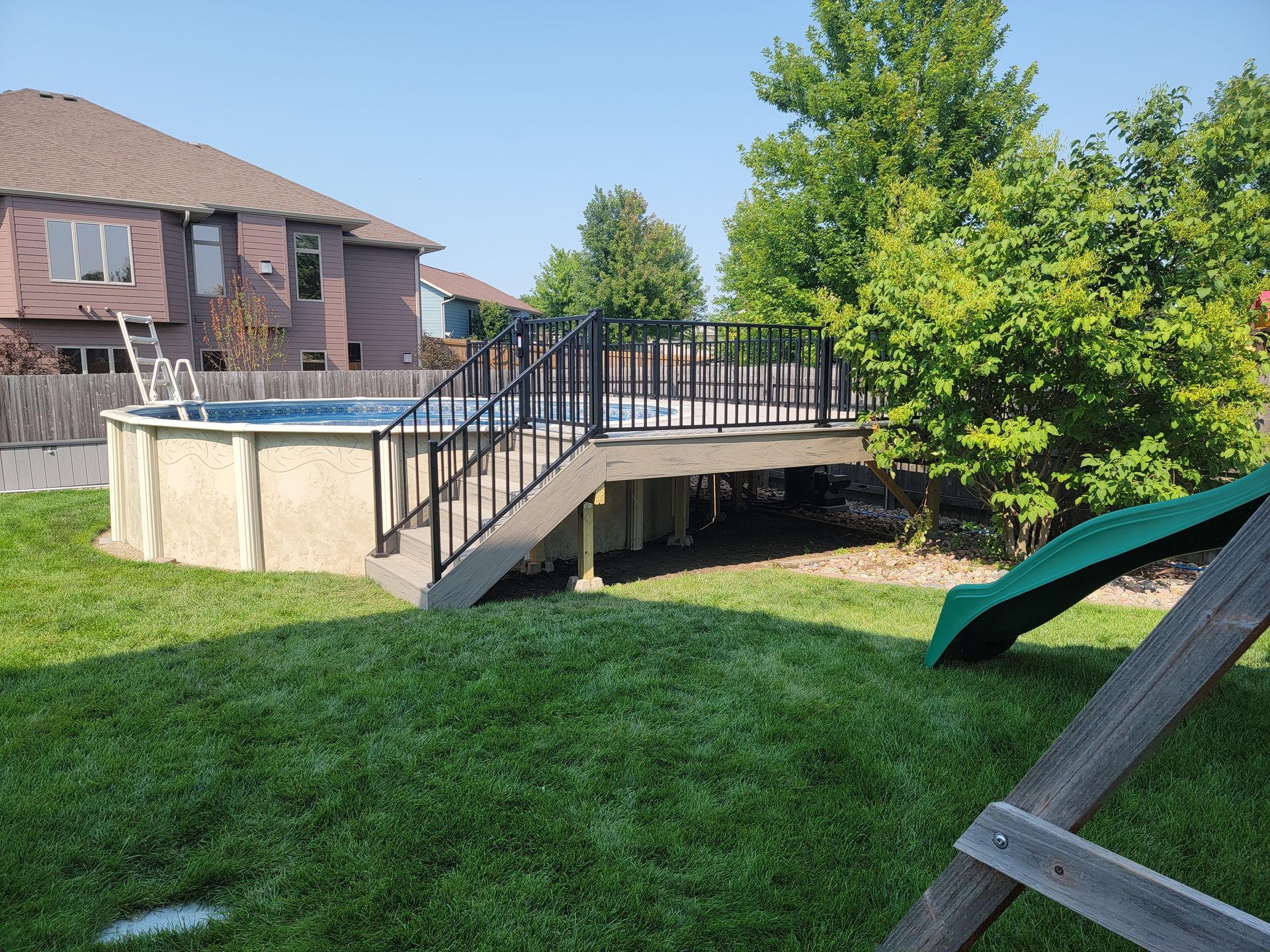 A backyard with a swimming pool and a deck