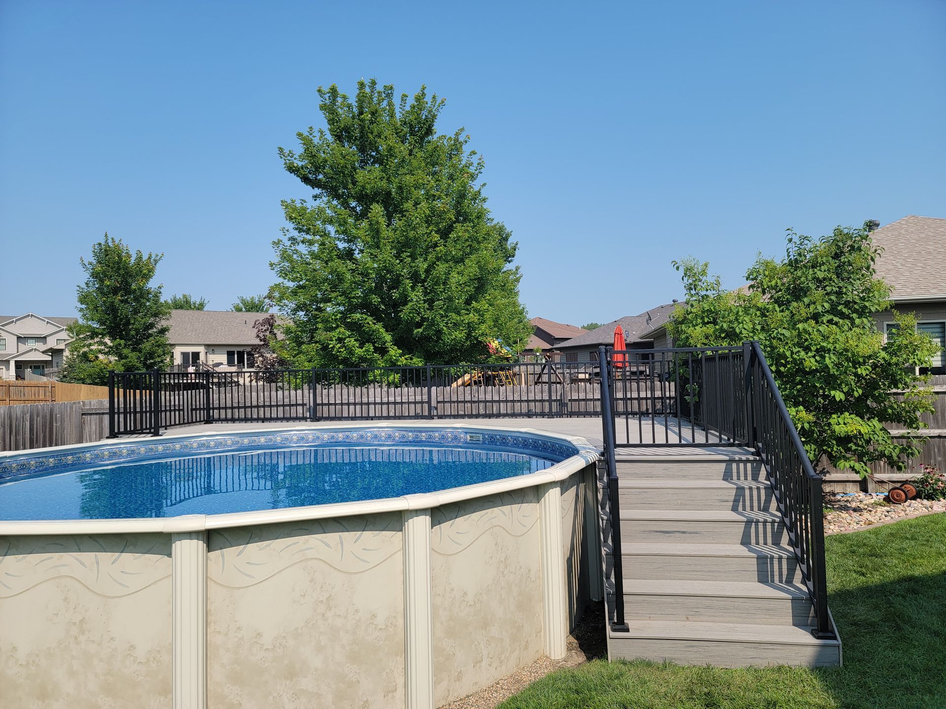 A swimming pool with stairs leading to it in a backyard