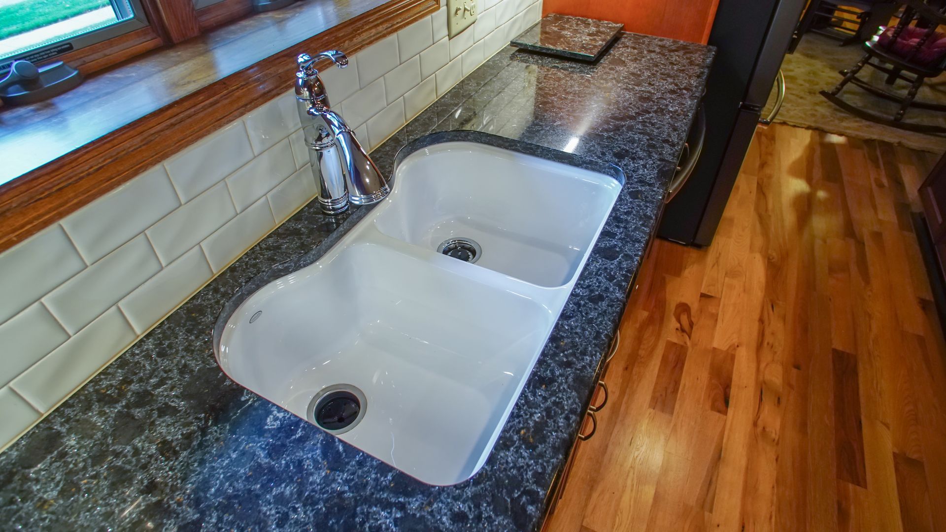 A kitchen sink is sitting on top of a granite counter.